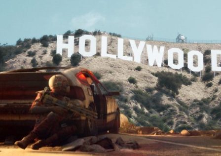 screenshot-from-arc-raiders-showing-a-chap-hiding-behind-a-car-overlaid-on-an-image-of-the-Hollywood-sign_w0CaAhN.jpg