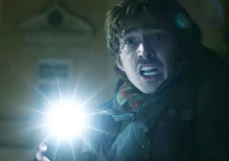 a-scared-man-shines-a-light-from-I-think-his-phone-is-Resident-Evil-movie-trailer.jpg